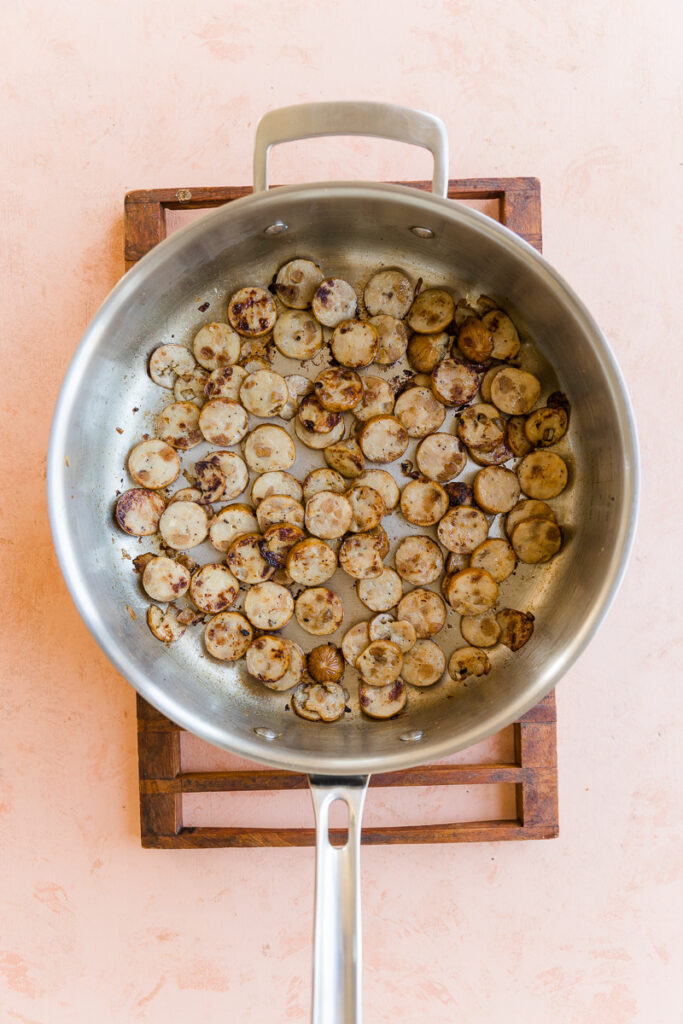 Cooked chicken sausage in a large pan.