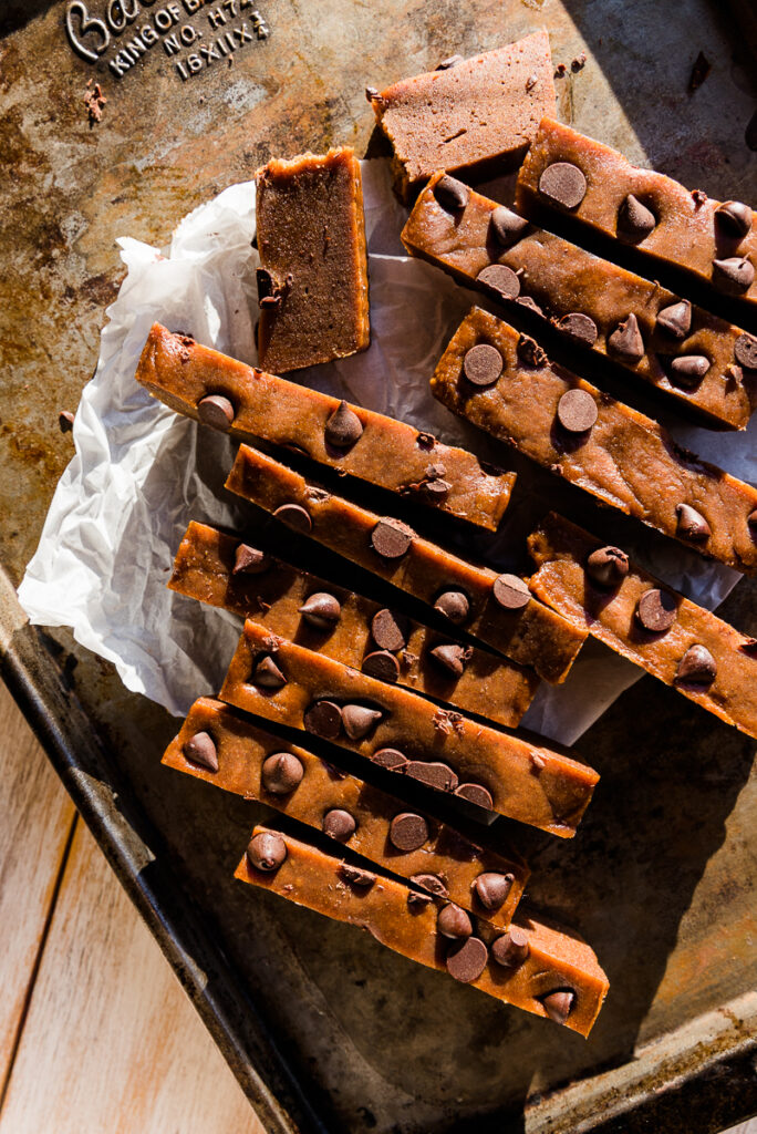 Protein bars cut into long strips on a parchment paper lined baking sheet.