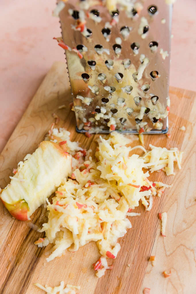 Grated apple on a cutting board.