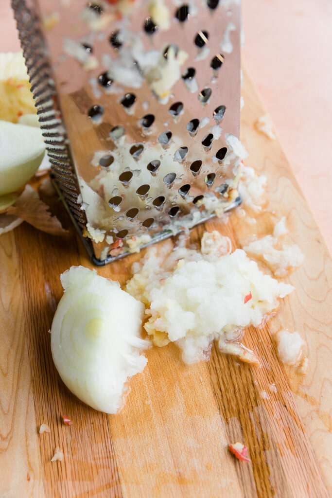 Grated onion on a cutting board.