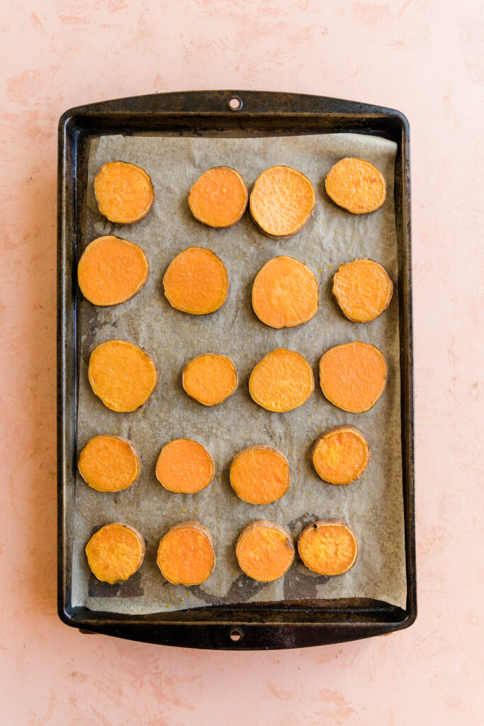 Sweet potato discs on baking sheet lined with parchment paper.