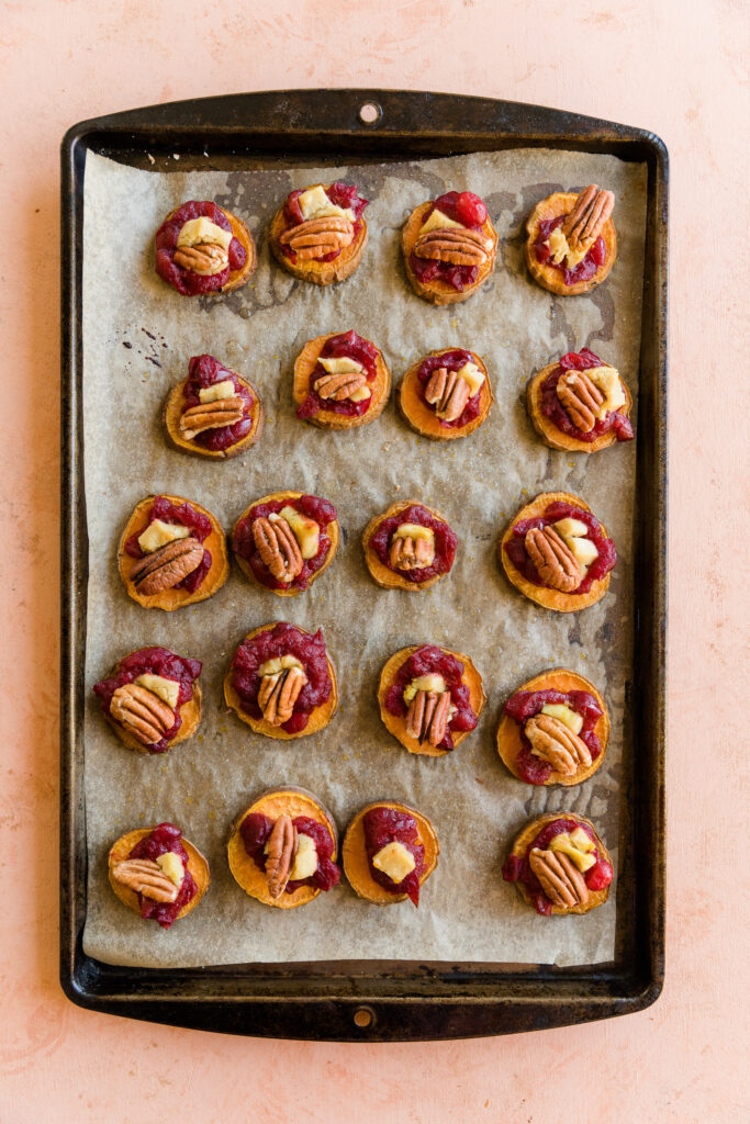 Sweet potato discs with baked cranberry sauce, brie cheese, and pecans.