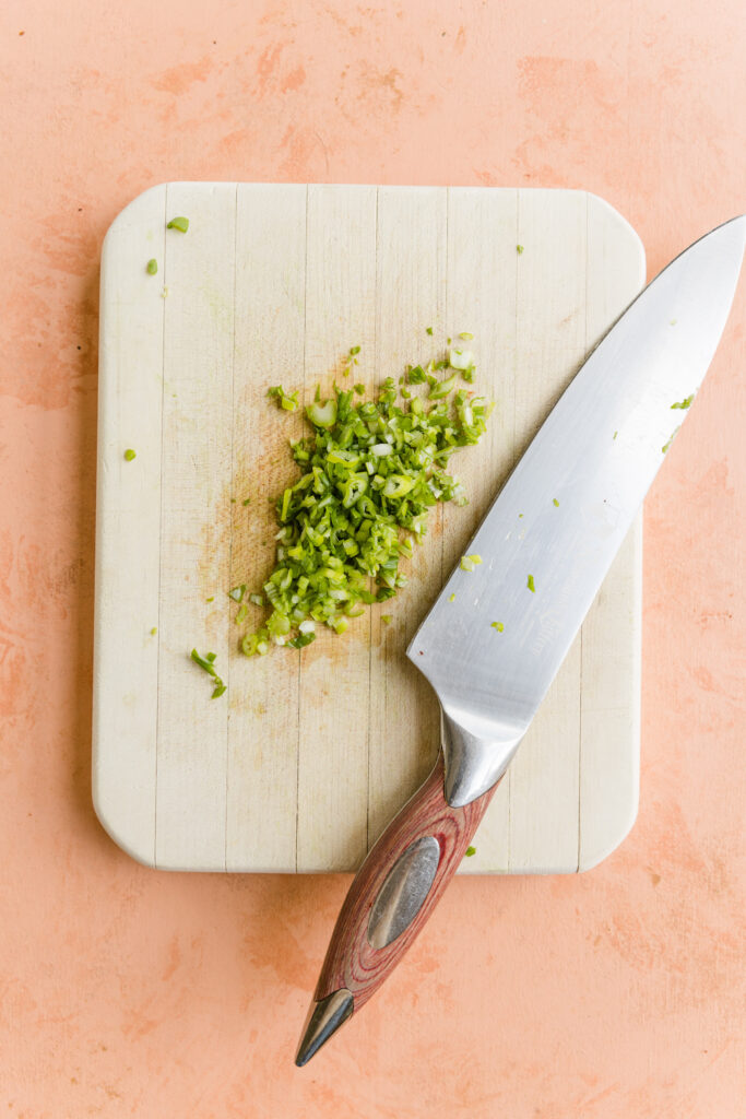 Green onions chopped on a cutting board.