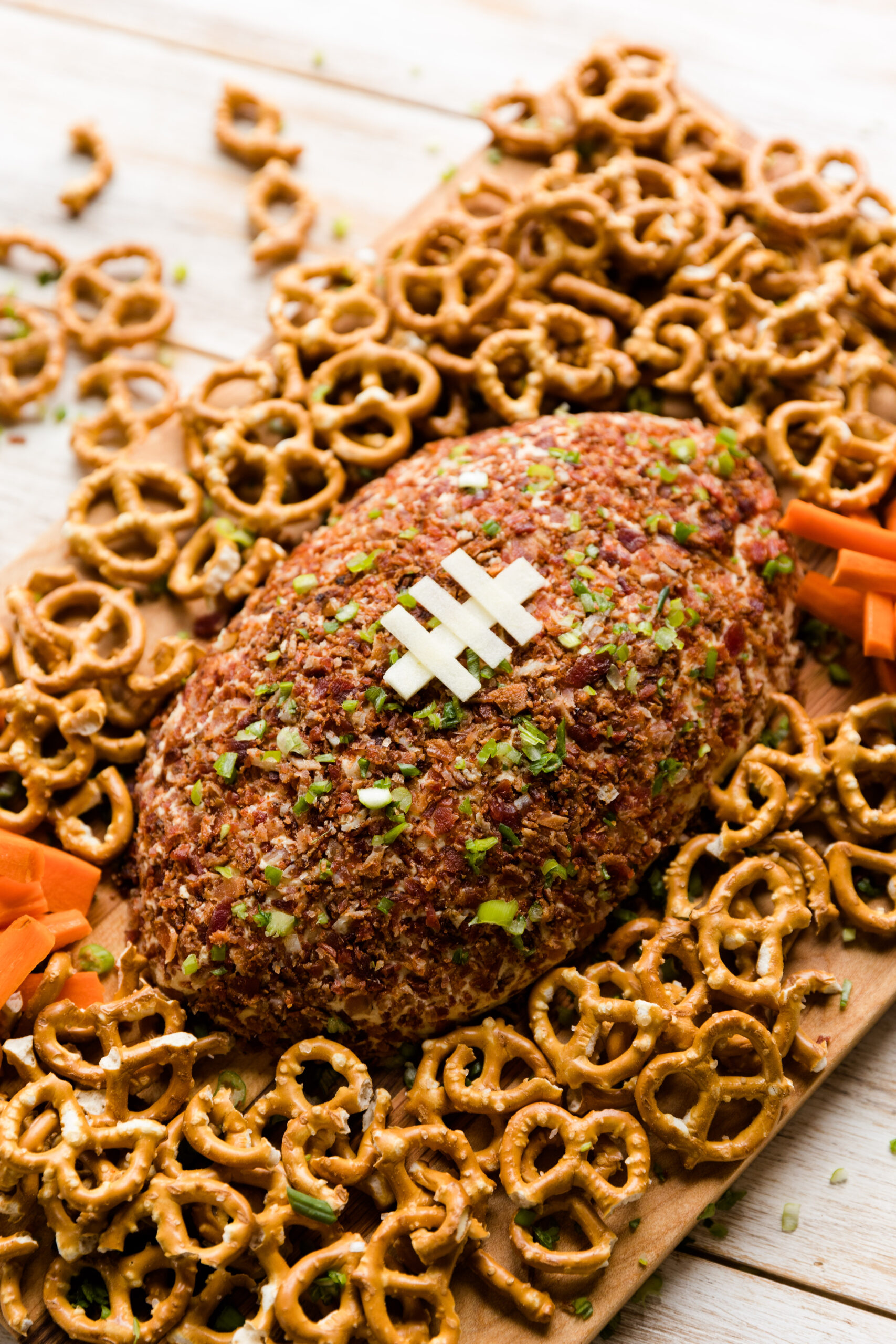 Football cheese ball with pretzels and carrot sticks.