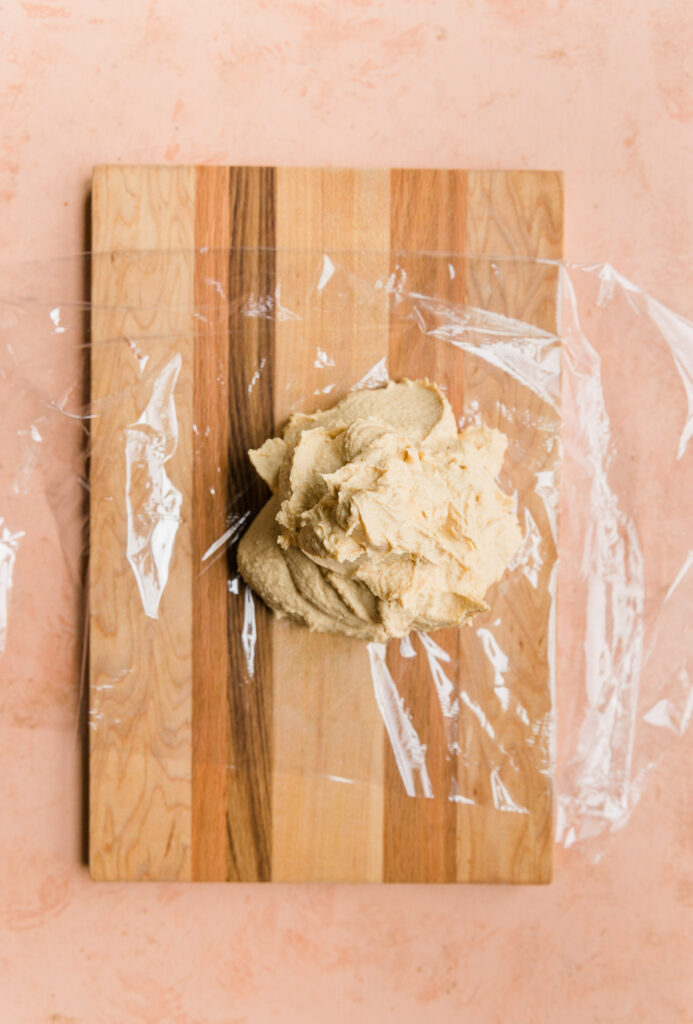 Football cheese ball mixture scooped out on plastic wrap.