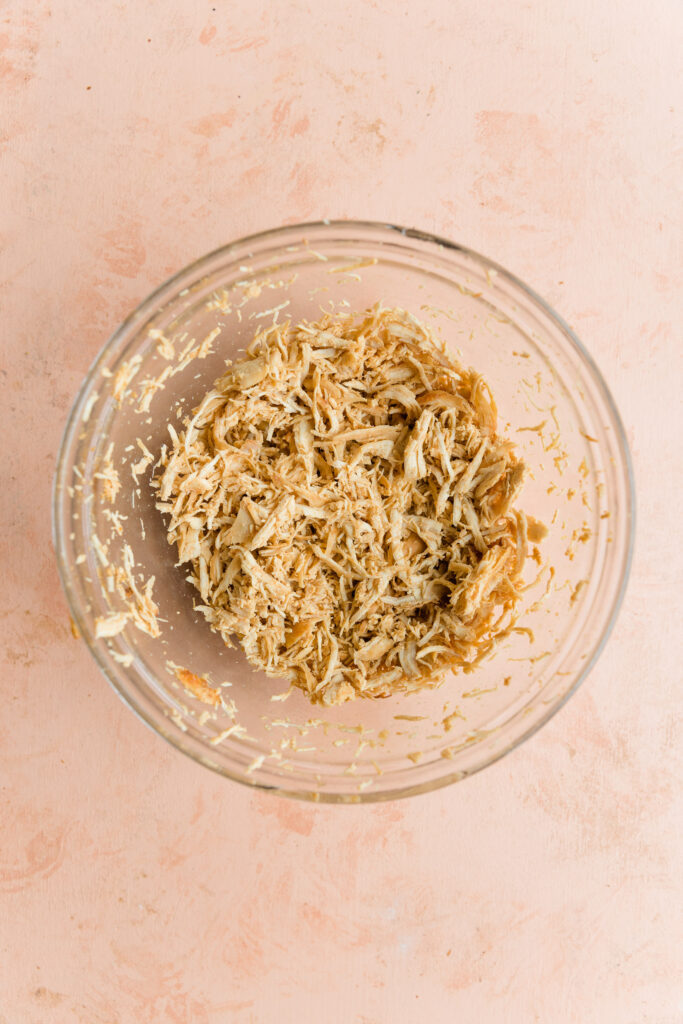 Shredded chicken in a mixing bowl.
