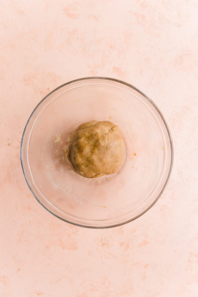 Sugar cookie dough ball in glass bowl.