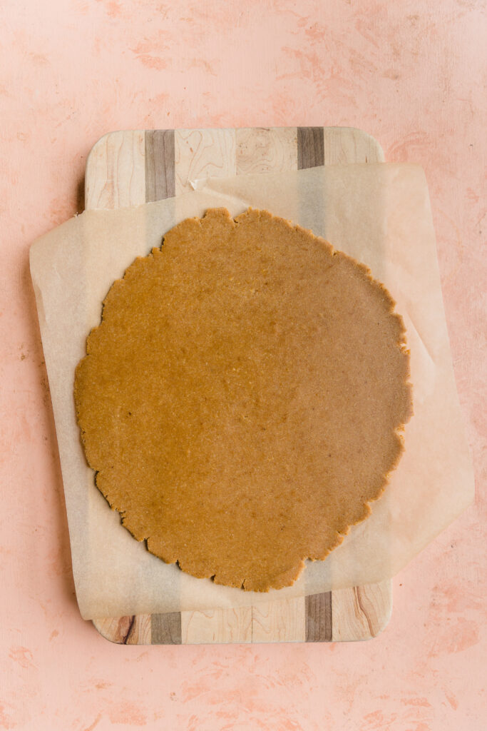 Sugar cookie dough rolled out on parchment paper.