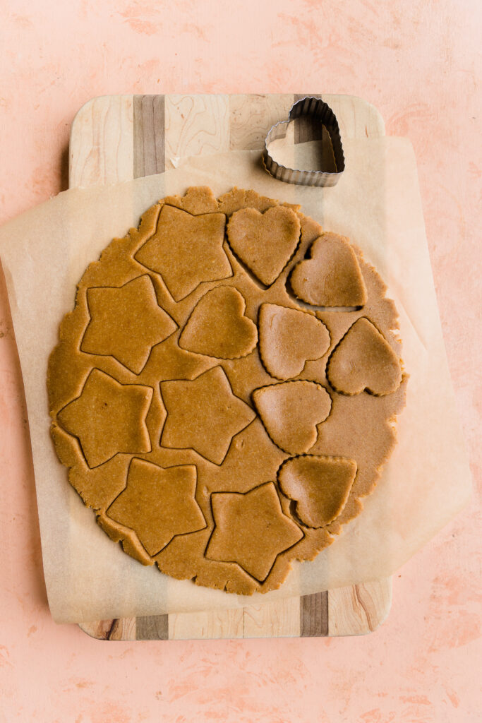 Sugar cookie dough cut out into stars and hearts.