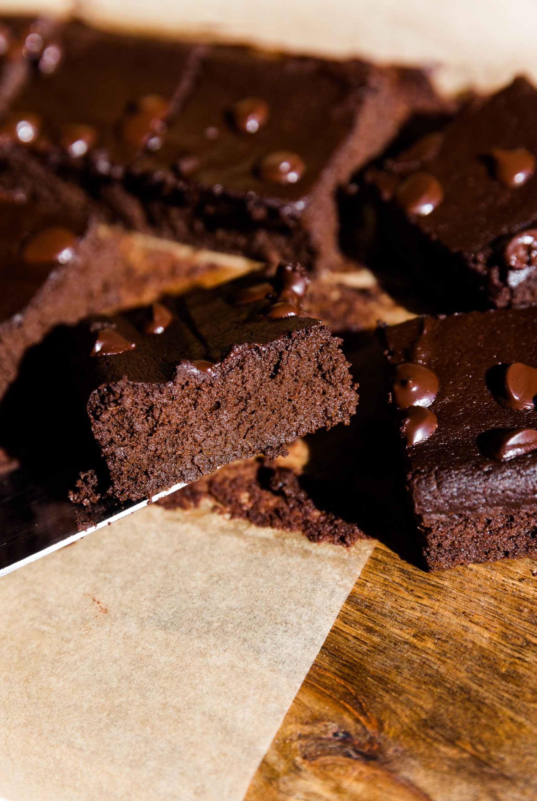 Flourless sweet potato brownies cut into perfect squares on parchment paper.
