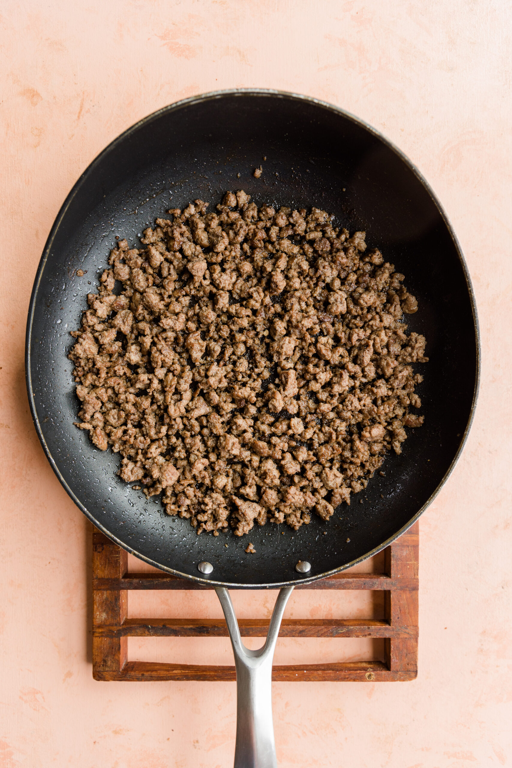 Ground beef cooking in skillet.