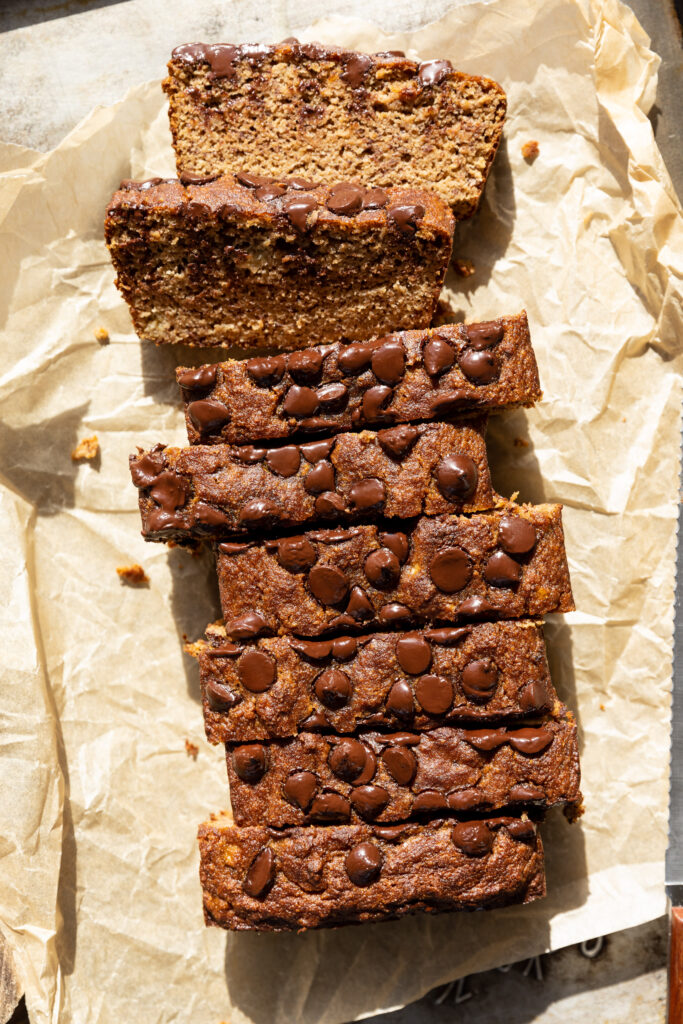 Banana bread cut into slices with melted chocolate chips on top.