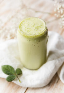 Shamrock protein shake in glass cup.