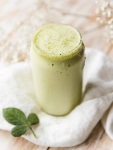 Shamrock protein shake in glass cup.