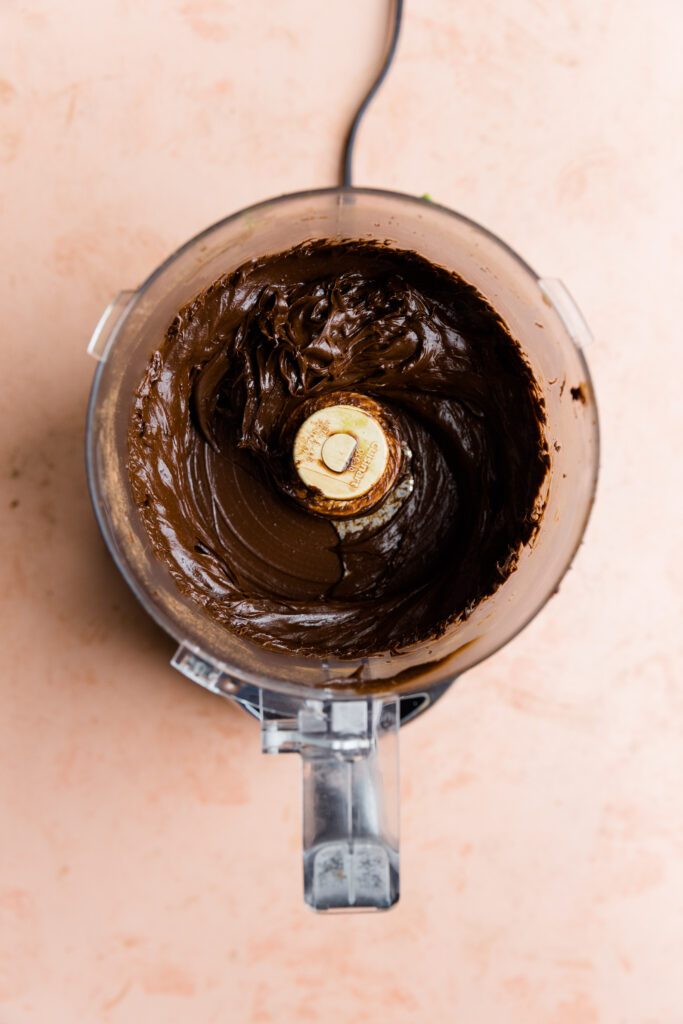 Creamy chocolate avocado frosting in food processor.