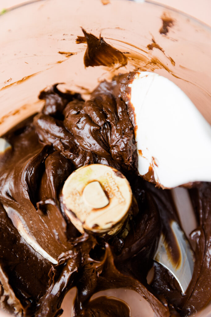 Spatula scooping out chocolate avocado frosting.