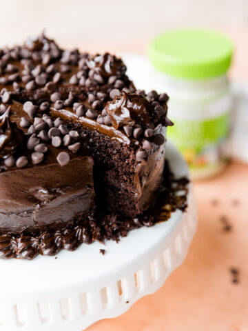 Chocolate cake with chocolate frosting and chocolate chips on top.