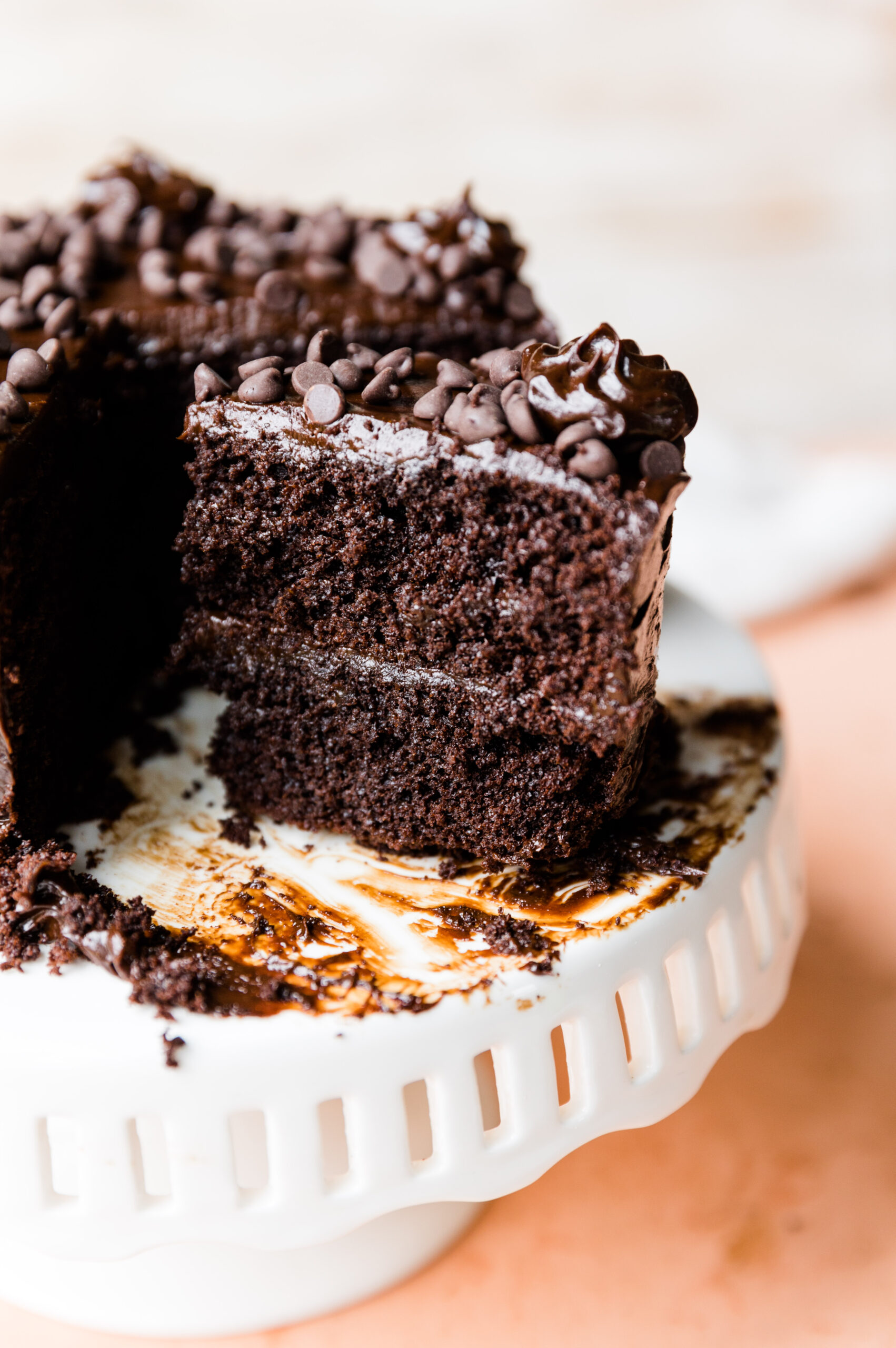 Slice of chocolate layer cake on a cake stand.