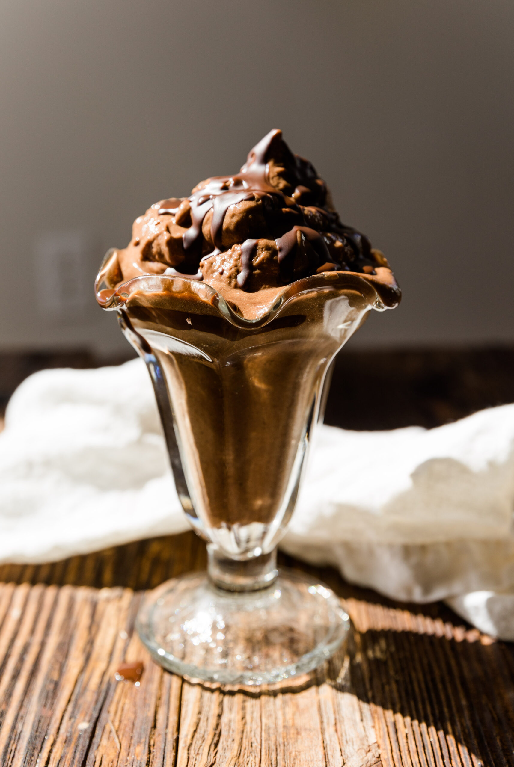 Glass ice cream cup filled with chocolate banana ice cream.