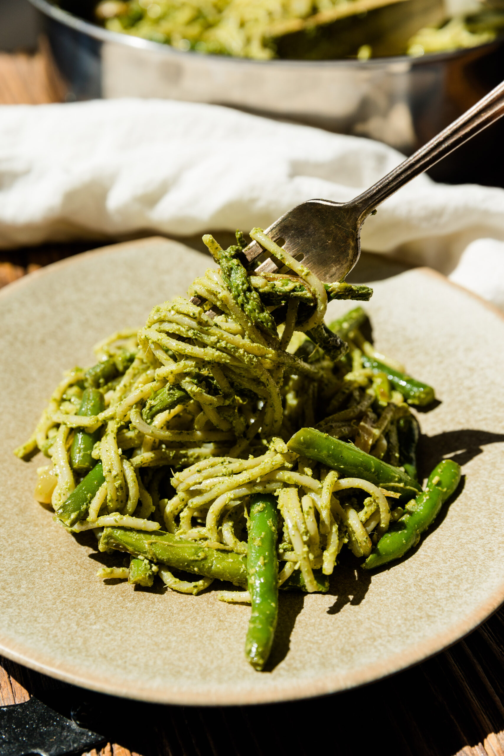 Fork twirling pesto pasta.
