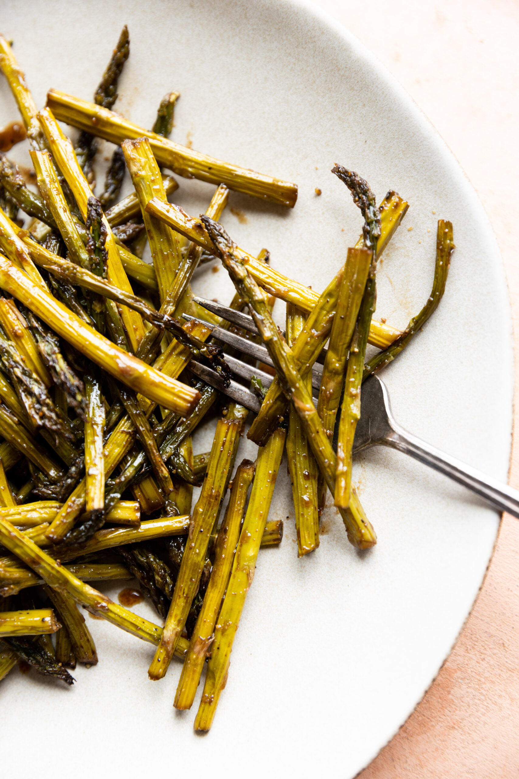 Roasted balsamic asparagus on a white plate.
