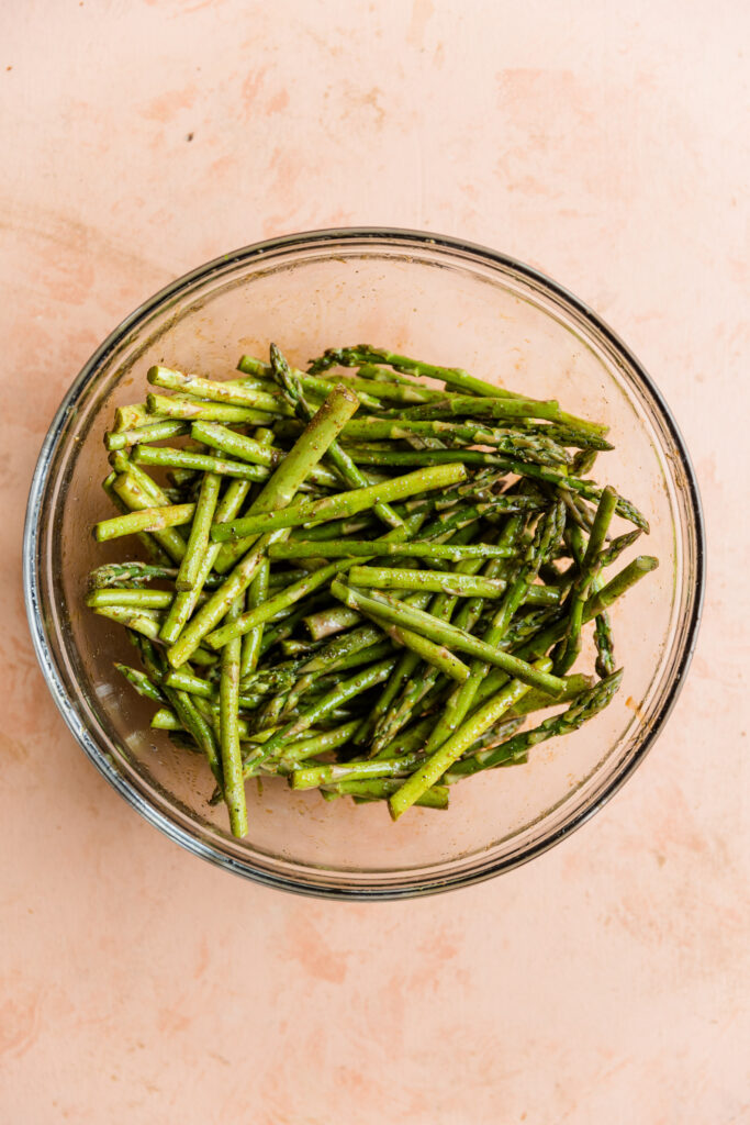 Asparagus halves in a glass mixing bowl.