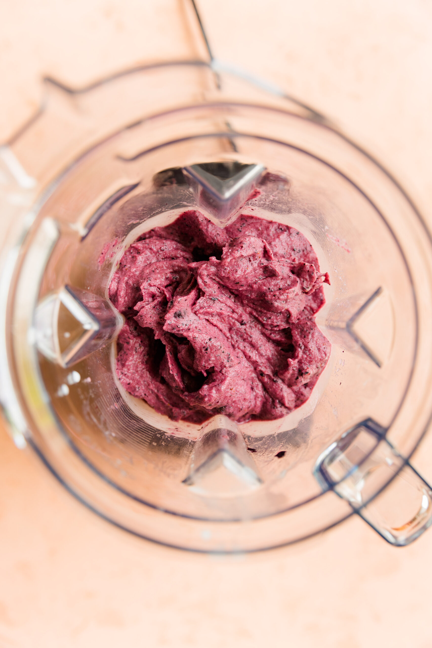 Blueberry nice cream in blender with chocolate chips folded in.