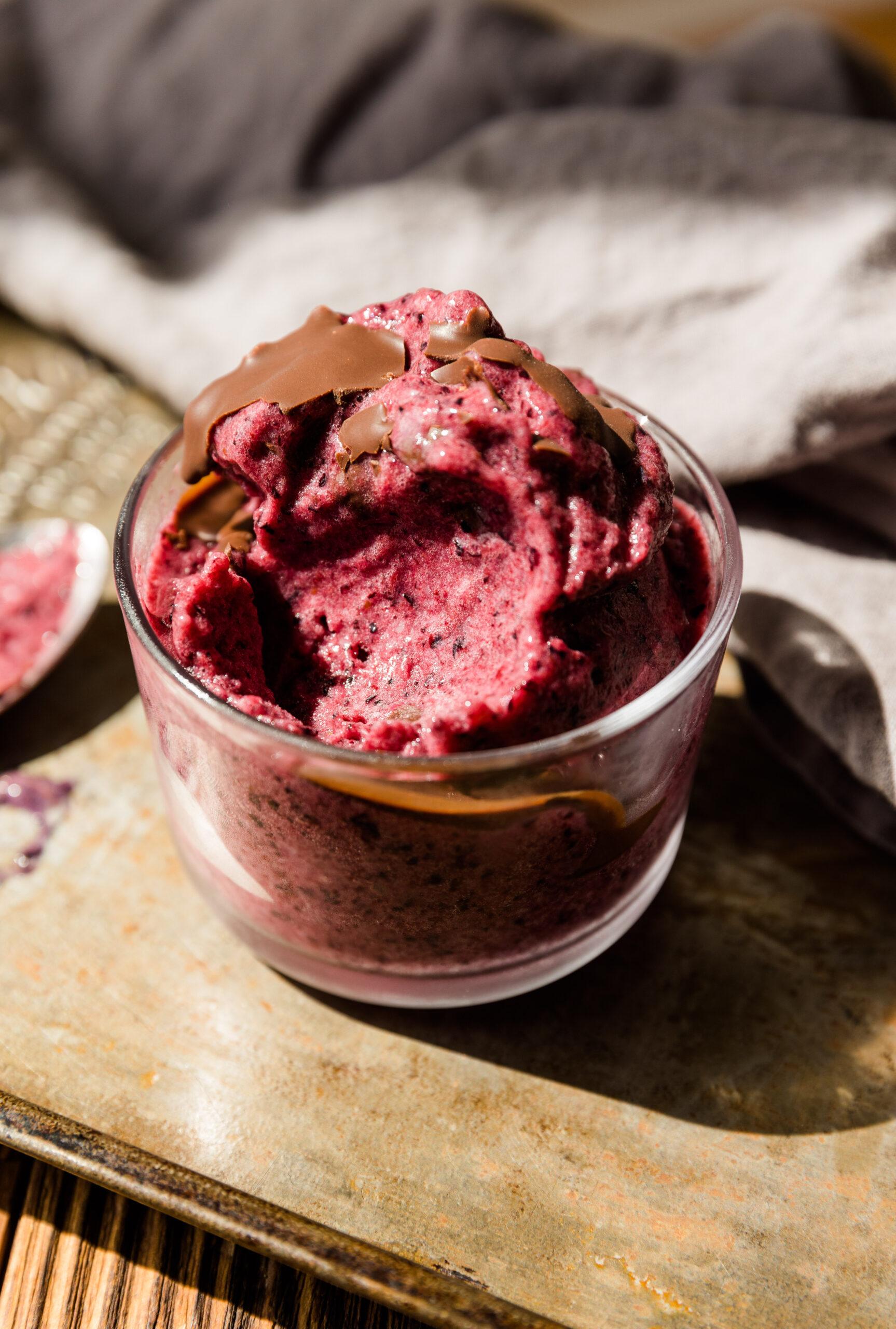 Blueberry nice cream with melted chocolate on top.