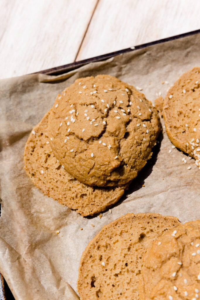 Paleo burger buns cut in half on parchment paper.