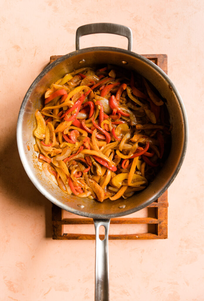 Cooked fajita peppers and onions in pan.