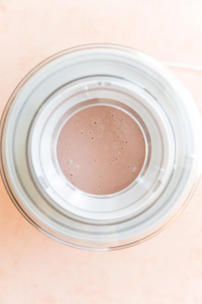 Strawberry ice cream mixture in ice cream maker.