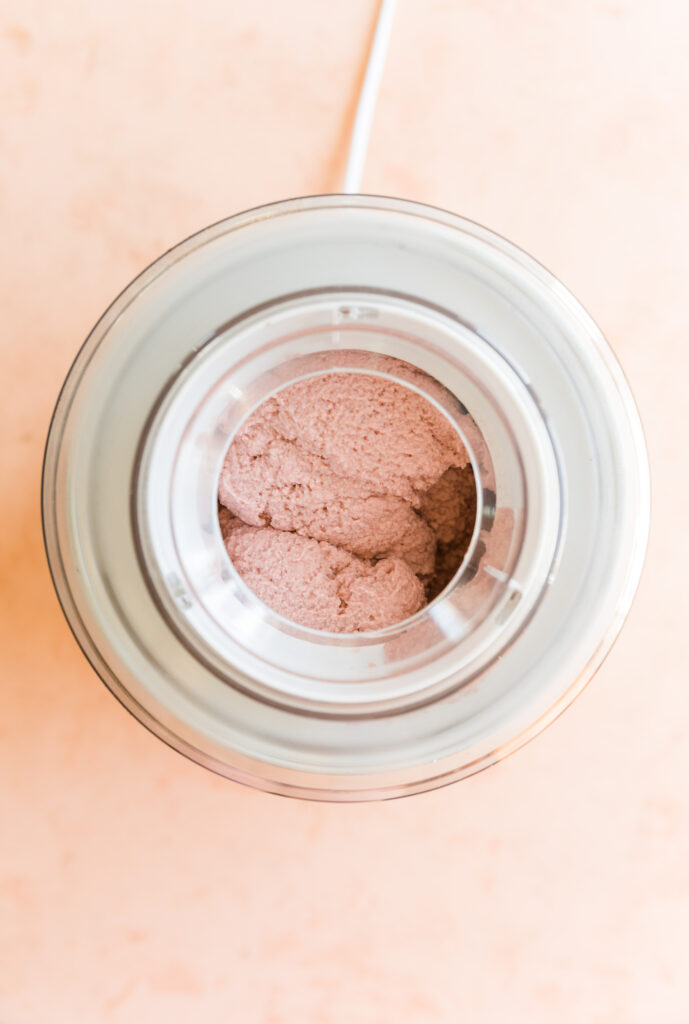 Creamy strawberry ice cream in ice cream maker.