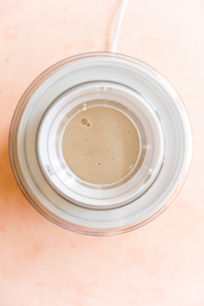 Coconut ice cream mixture in ice cream maker.
