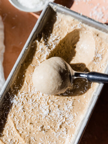 Ice cream scooper scooping out coconut ice cream.