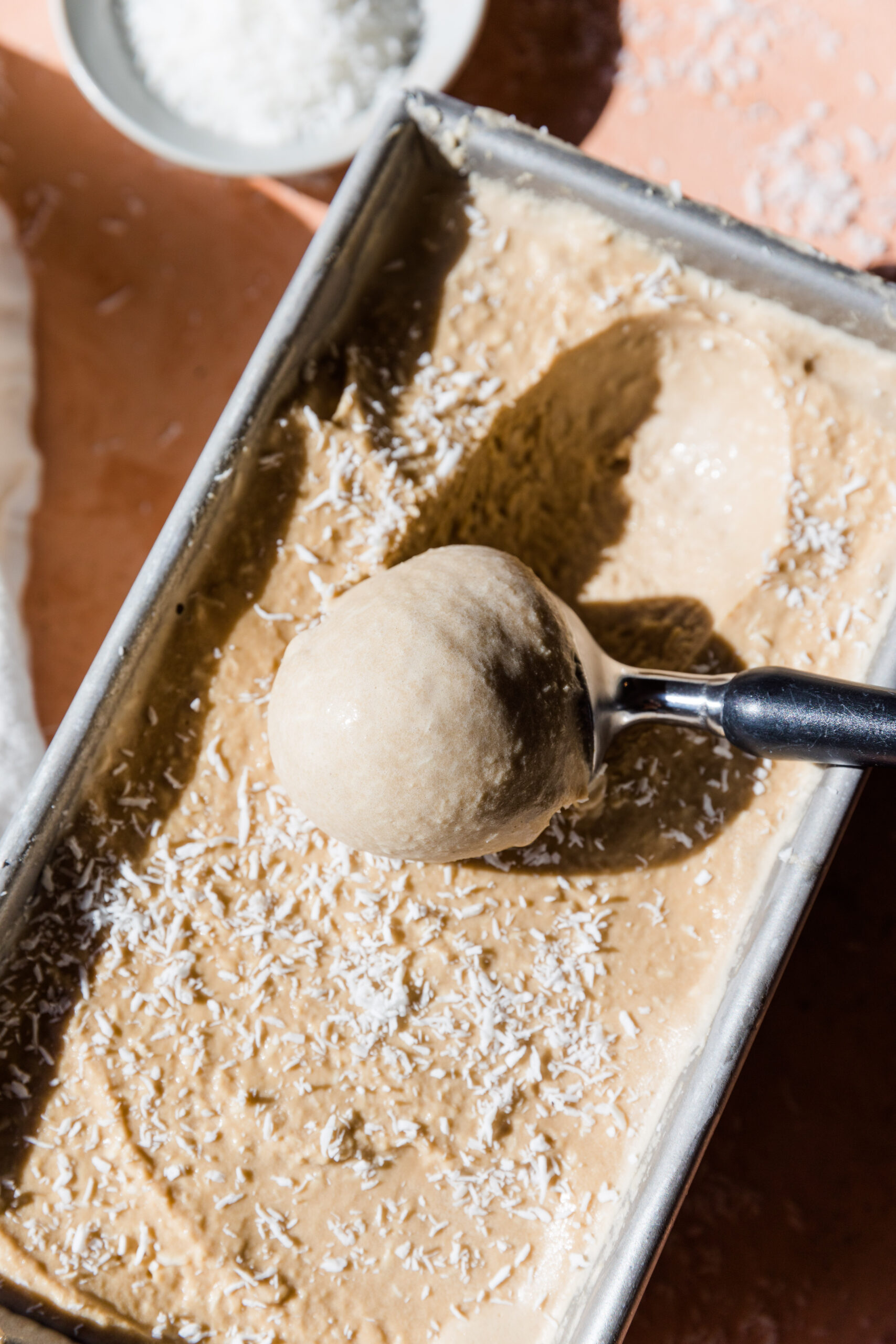 Ice cream scooper scooping out coconut ice cream.