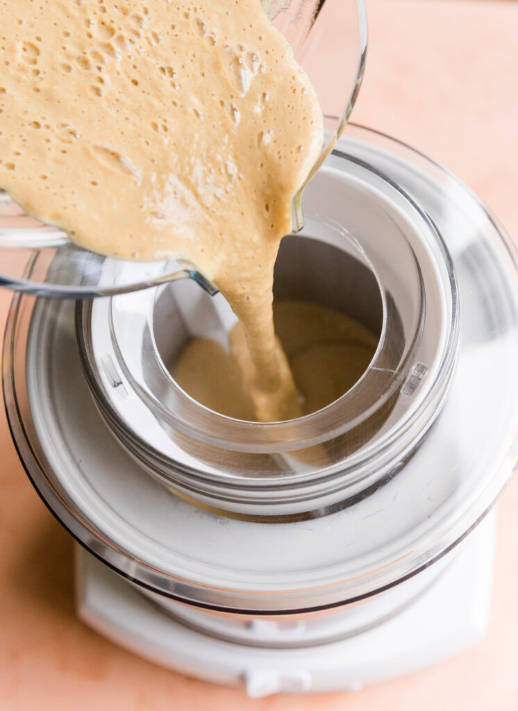 Pouring lemon ice cream into ice cream maker.