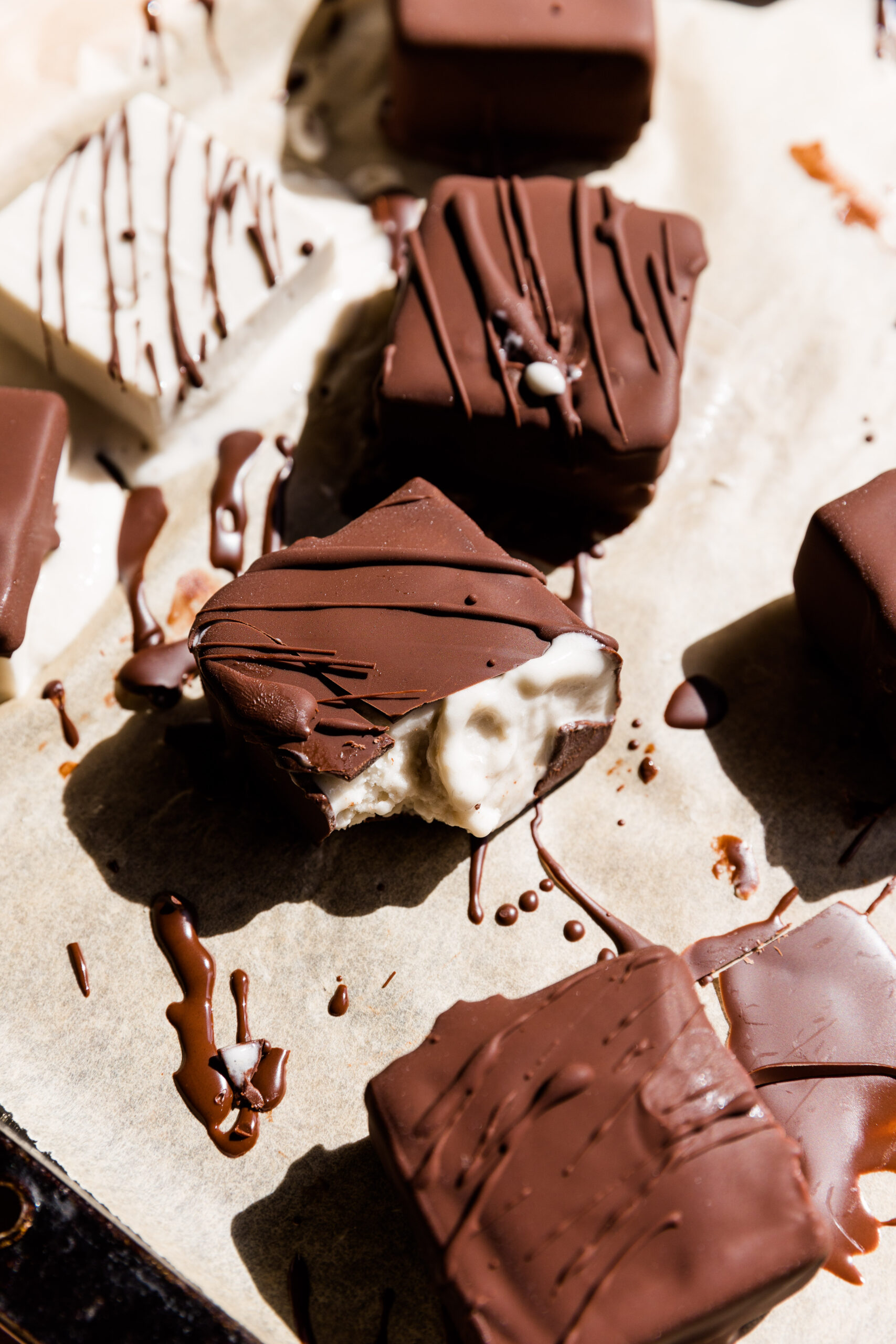 Dairy free klondike bar with a bite taken out that has melted vanilla ice cream.