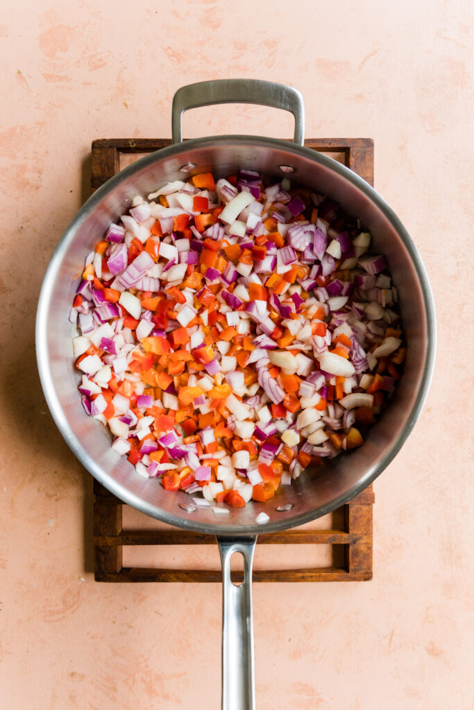 Bell peppers, red onion, sweet onion, and garlic in large pan.