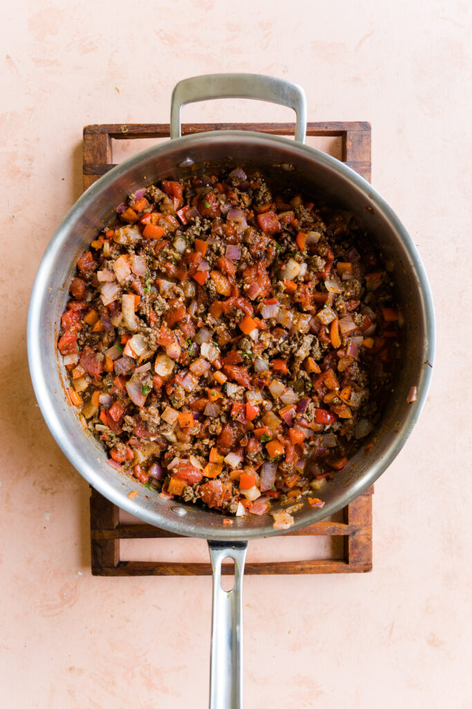 Cooked vegetables in a pot with leftover taco meat, fire roasted diced tomatoes, and cilantro.