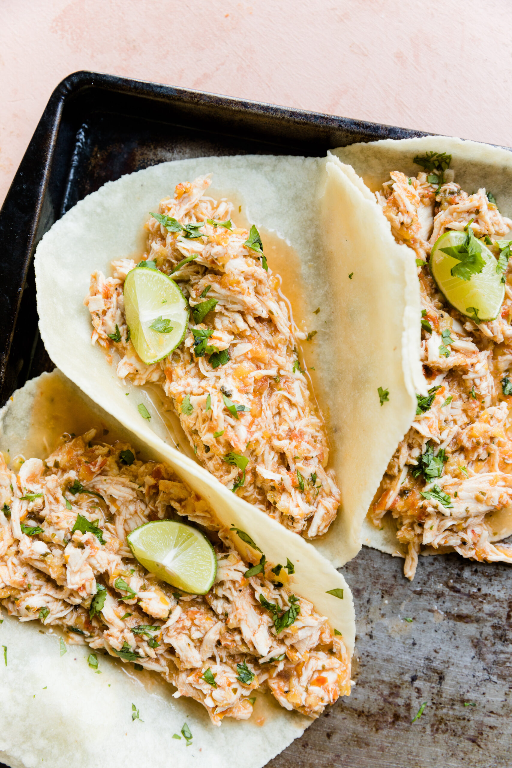 Peach salsa shredded chicken in tortillas with lime and cilantro.