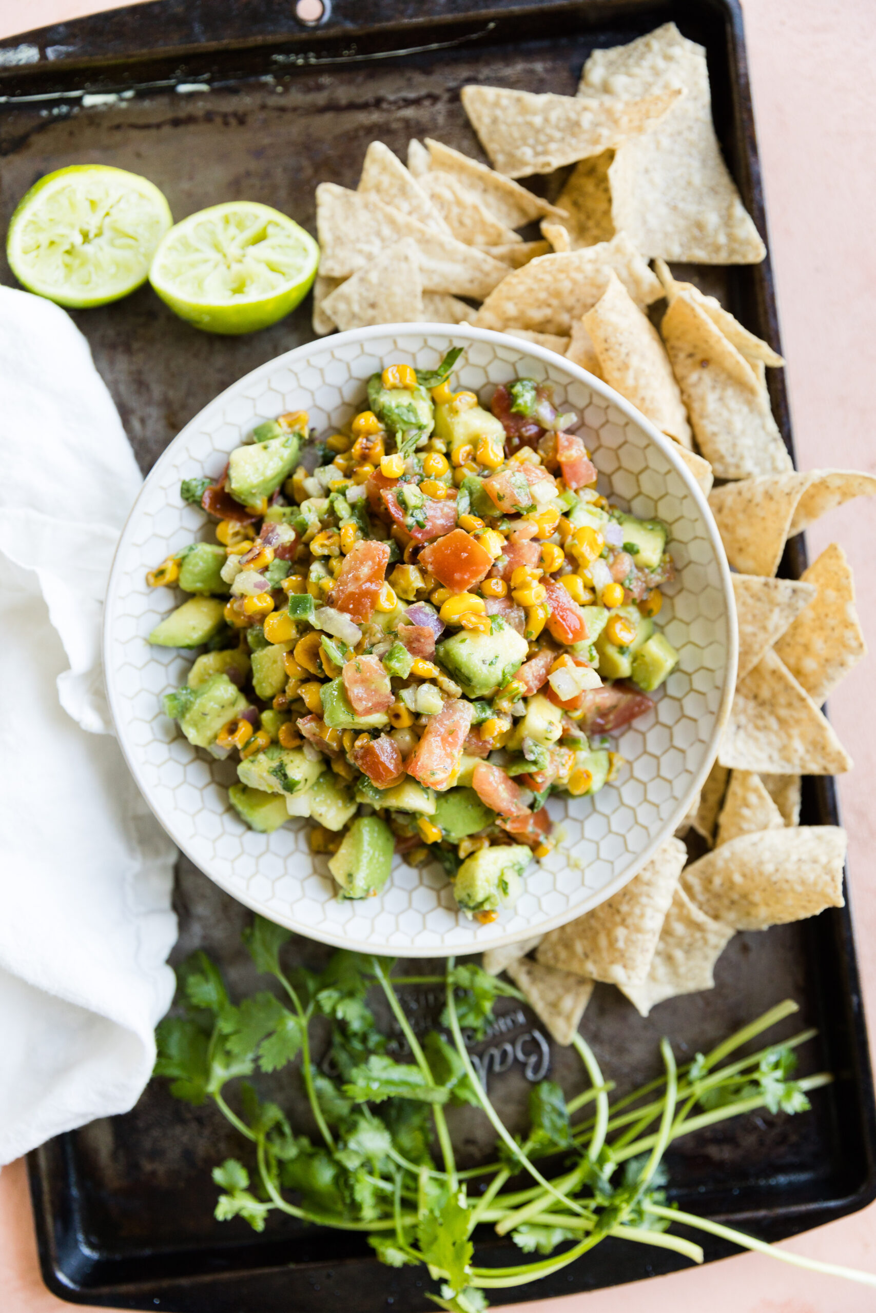 Avocado corn salsa in a bowl with chips on the side.