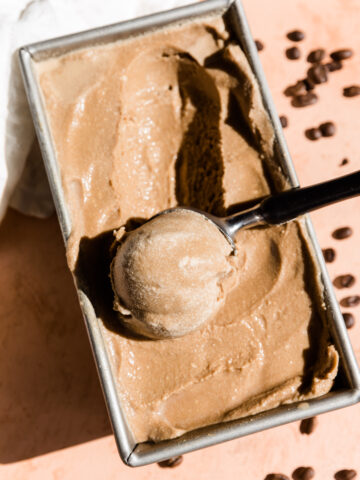 Ice cream scooper scooping out coffee ice cream.