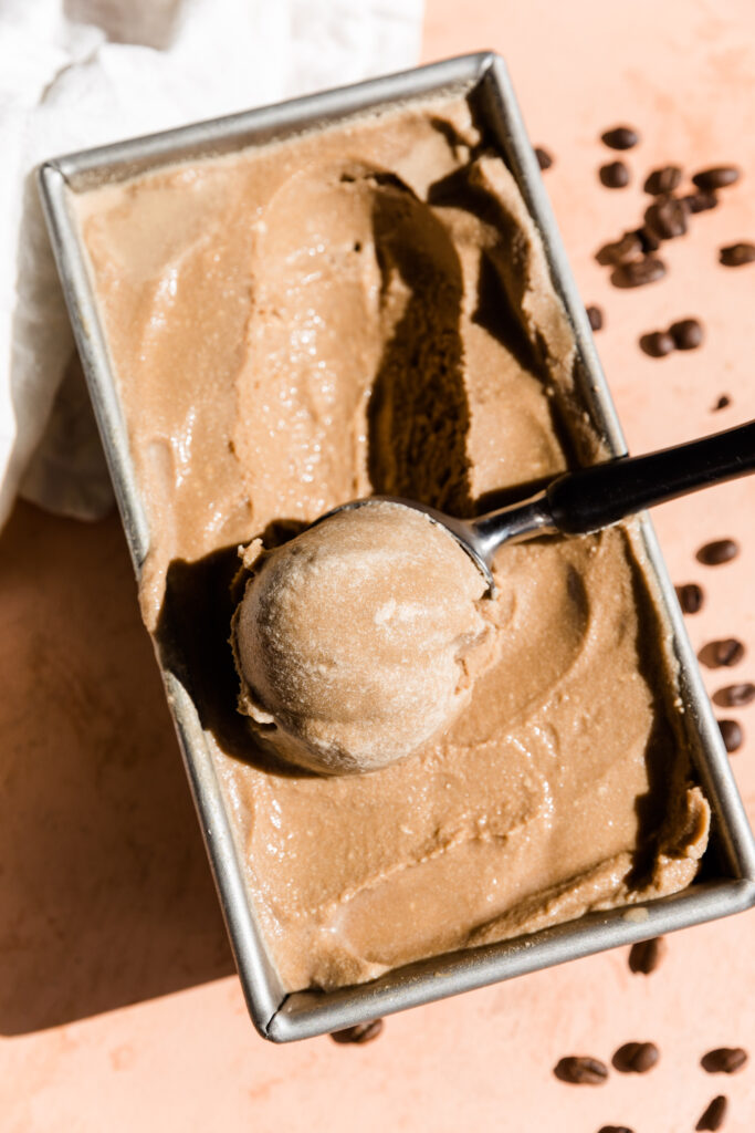 Ice cream scooper scooping out coffee ice cream.