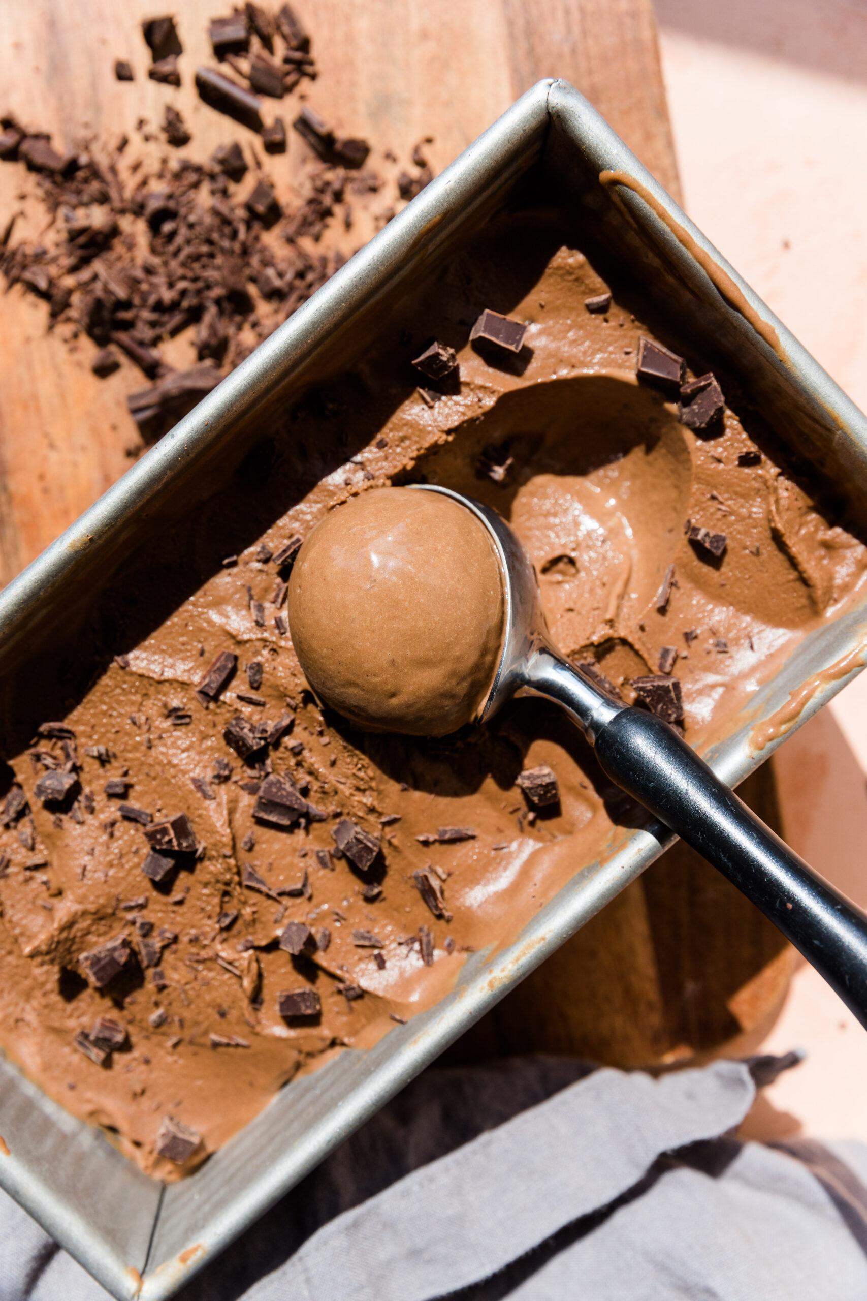 Ice cream scooper scooping out a perfect ball of chocolate ice cream.