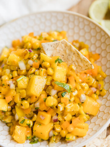 Chip scooping up mango corn salsa.