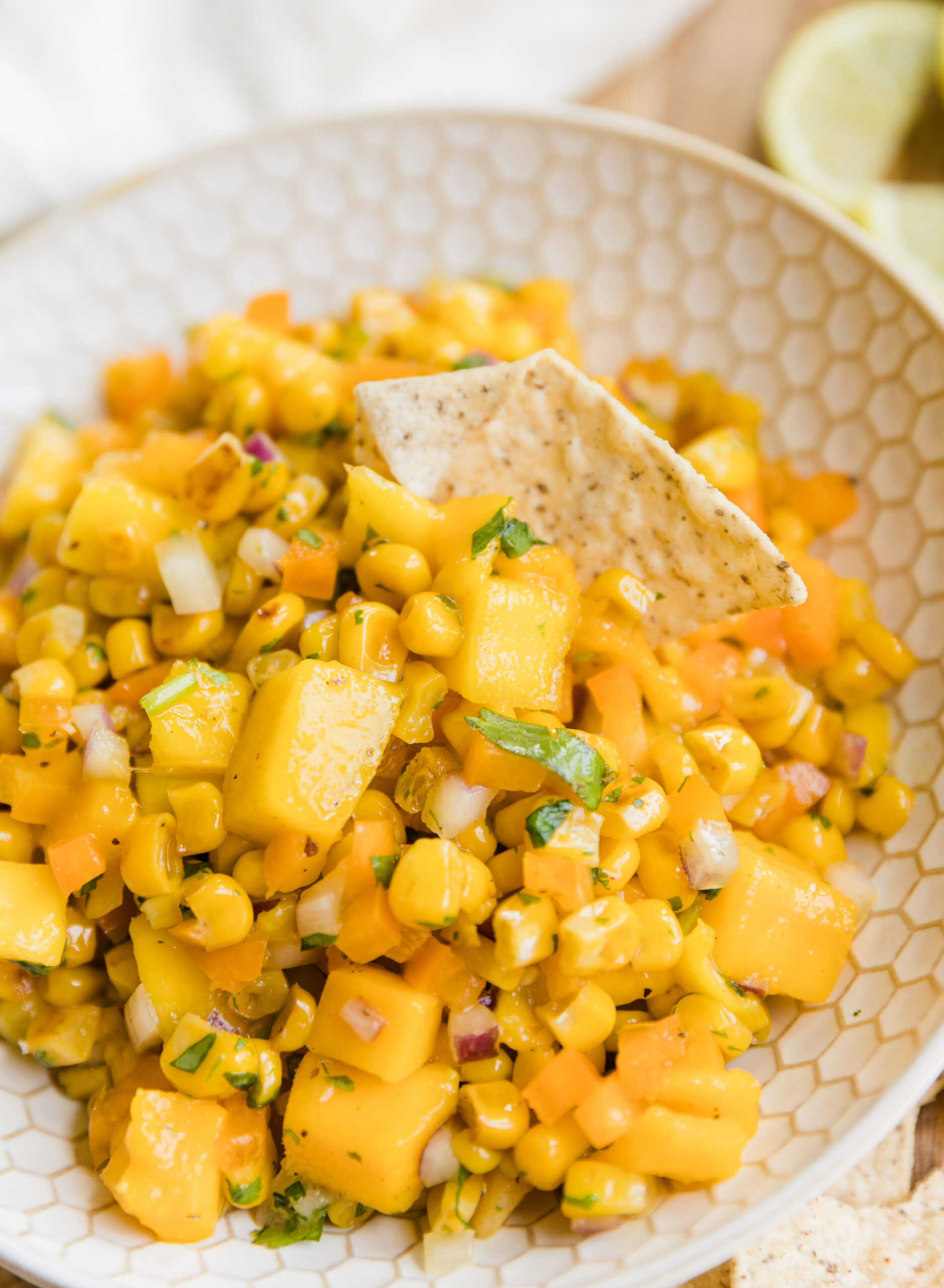 Chip scooping up mango corn salsa.