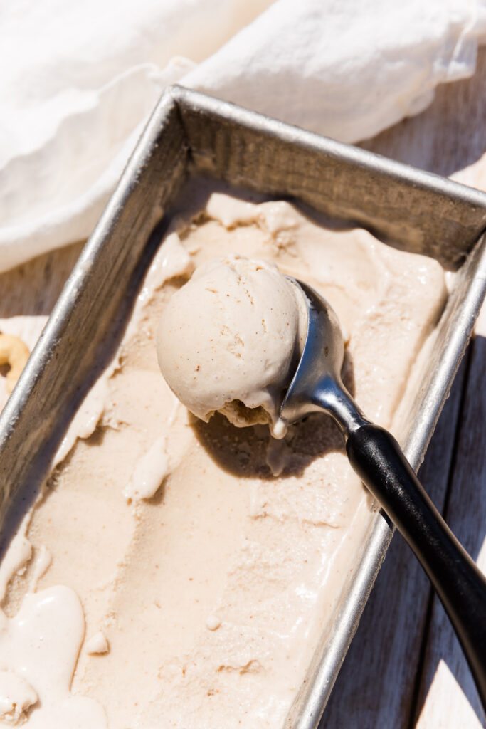 Scooping vanilla ice cream out of loaf pan.