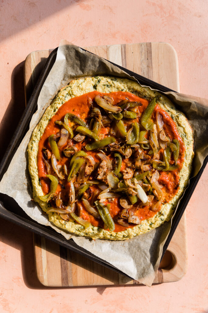 Uncooked pizza toppings on cauliflower crust.