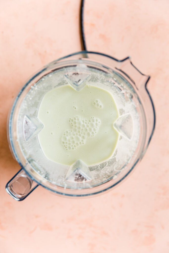Creamy vegan mint ice cream mixture in blender.