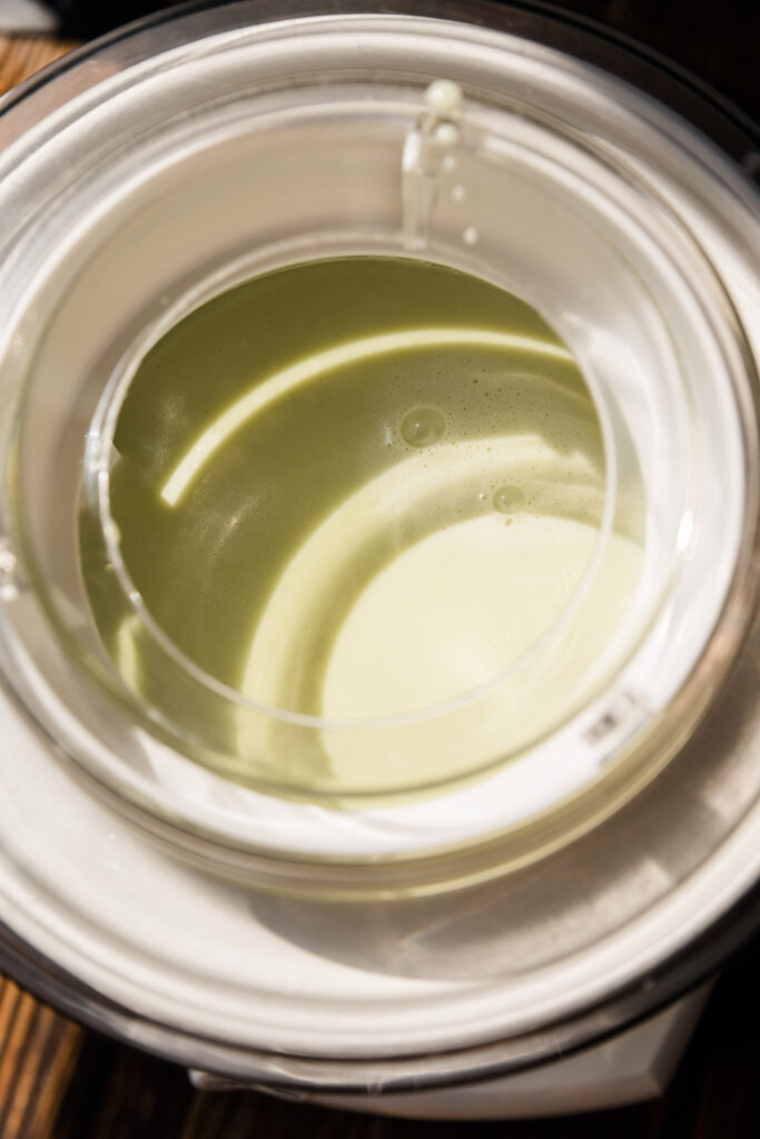 Creamy vegan ice cream mixture in ice cream maker.
